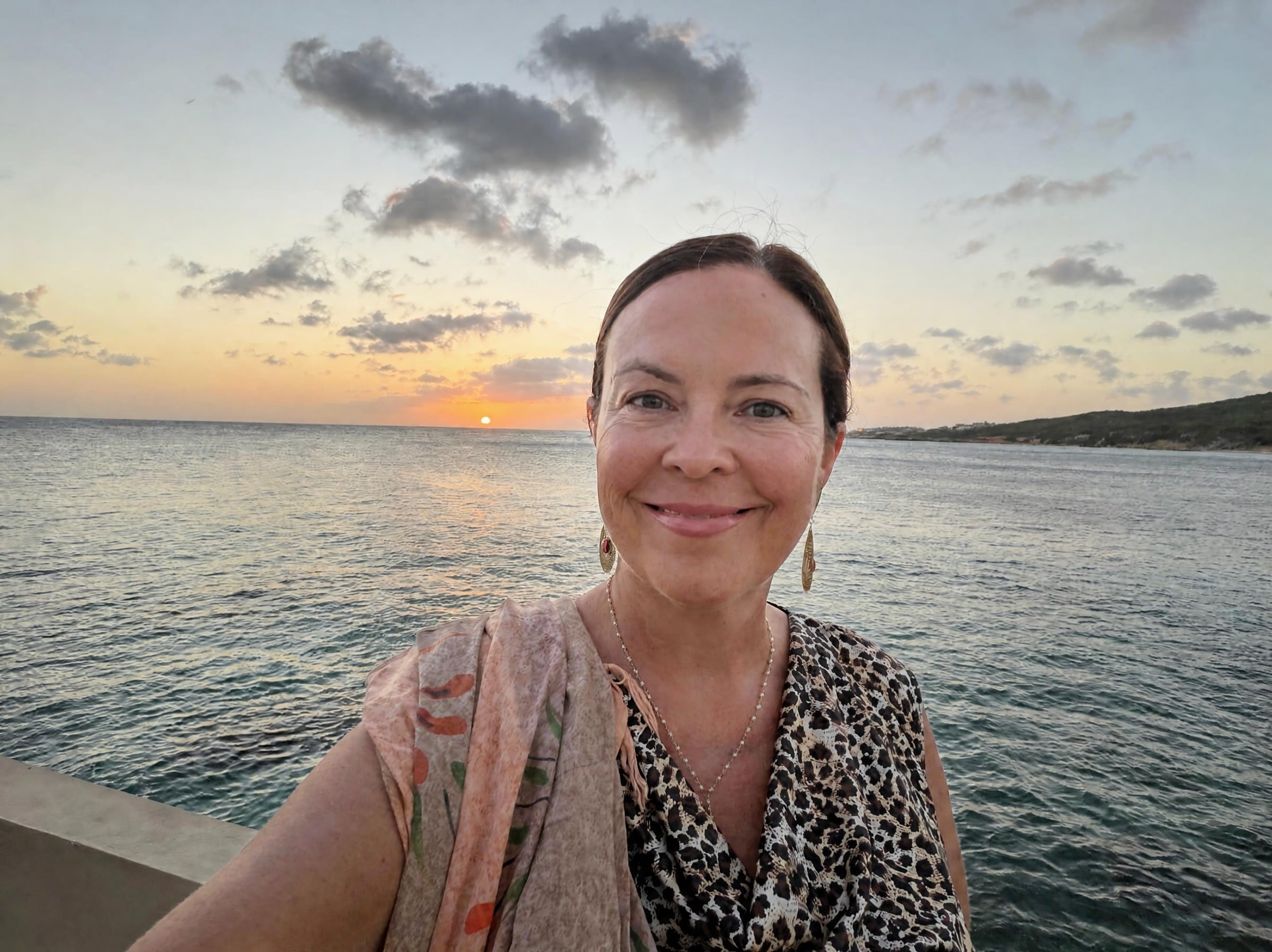 Jen in Curaçao at sunset, hand extended toward the camera